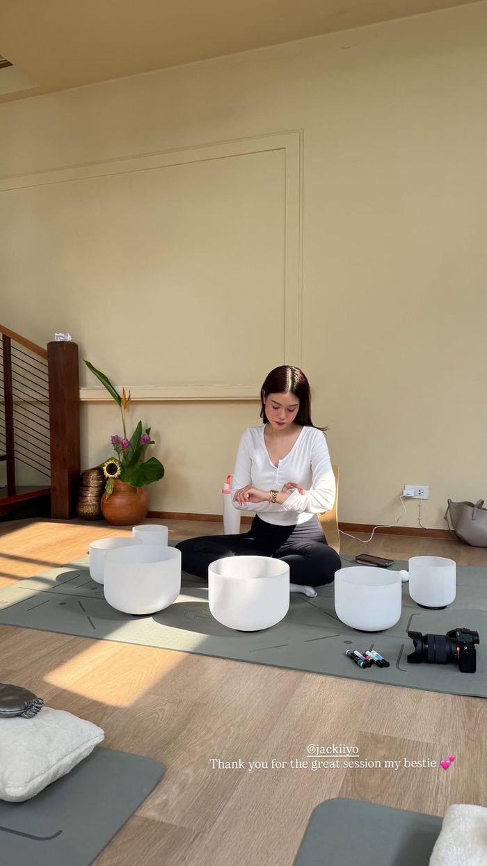 A studio floor set with singing bowls and cushions before a sound bath session
