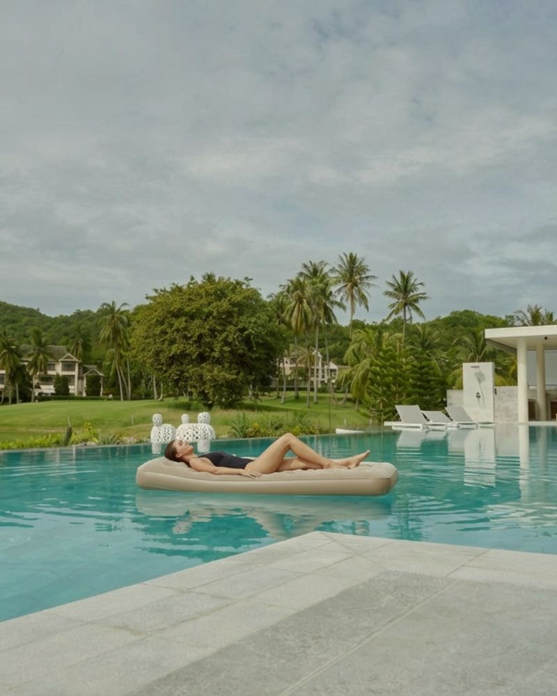A private villa pool set with floating beds for a daytime wellness experience